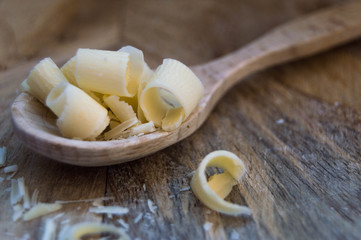 Wooden spoon in a rustic background with white chocolate.