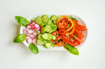 Fresh salad in a white plate. Cut vegetables. Top view.