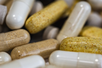 Piles of pills and capsule on white background. Selective focus