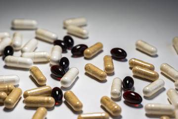 Piles of pills and capsule on white background. Selective focus