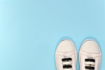 White sneakers with black and white silicone lacing. The visible front half of the shoe next to...