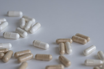 Piles of pills and capsule on white background. Selective focus