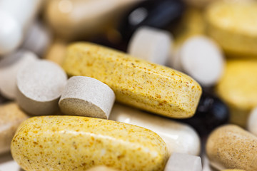 Piles of pills and capsule on white background. Selective focus