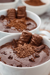 Two mugs of a hot chocolate with chocolate sticks