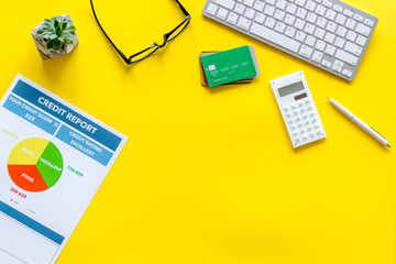 credit report with credit cards and keyboard on banker work place yellow background top view mock up