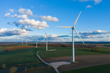 Cinq éoliennes au milieu des champs au crépuscule