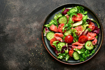 Vegetable salad with salmon and salad leaves mix. Top view with copy space.