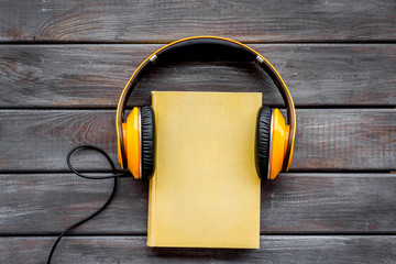listen to audio books with headphone on wooden background flatlay