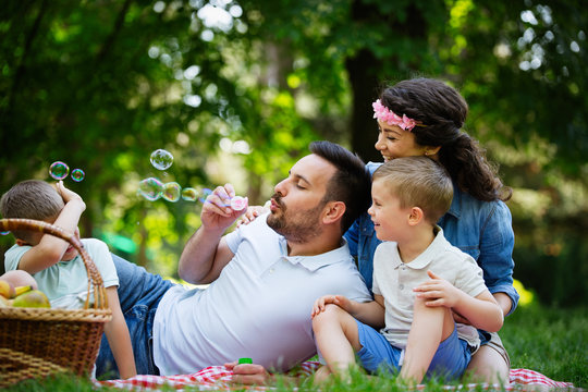 Family with children blow soap bubbles outdoors