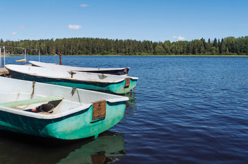 Naklejka na ściany i meble Boats on a lake pier near the forest