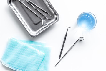 stomatologist instruments on white doctor's office desk background top view