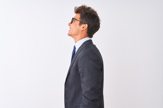 Young handsome businessman wearing suit and glasses over isolated white background looking to side, relax profile pose with natural face with confident smile.