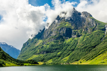 Green mountain peak above the small village in Naeroy fjord,  Aurlan, Sogn og Fjordane county, Norway