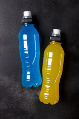 Isotonic energy drink. Bottles with blue transparent liquid, sport beverage on a black background