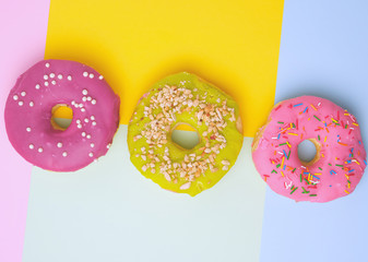 three round different sweet donuts with sprinkles