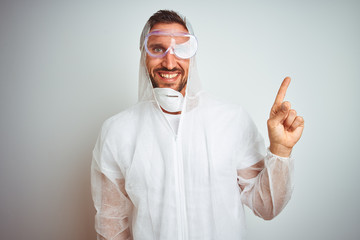 Painter man wearing professional worker equipment protection over isolated background with a big smile on face, pointing with hand and finger to the side looking at the camera.