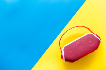 Audio listening with wireless speaker on yellow and blue background top view space for text