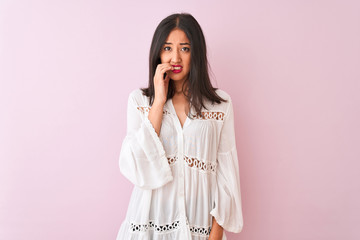 Young chinese woman wearing summer shirt standing over isolated pink background looking stressed...
