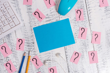 Writing tools, computer stuff and scribbled paper on top of wooden table