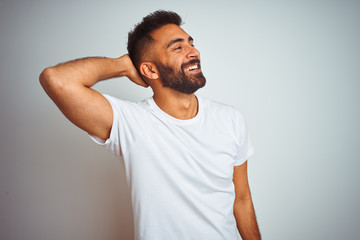 Young indian man wearing t-shirt standing over isolated white background smiling confident touching...