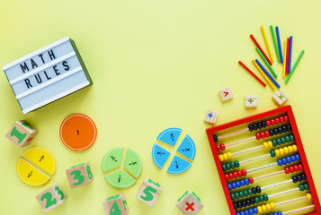 Creative Сolorful blocks, light box, fractions, abacus on yellow background. Interesting funny math for kids. Education, back to school concept. Geometry and mathematics materials. Flat lay
