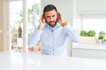 Fototapeta premium Handsome hispanic business man Trying to hear both hands on ear gesture, curious for gossip. Hearing problem, deaf