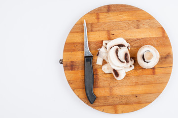 Mushrooms and knife on wooden board isolated on white background. Healthy food.Copy space