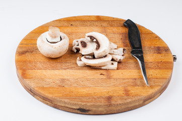 Mushrooms and knife on wooden board isolated on white background. Healthy food.Copy space