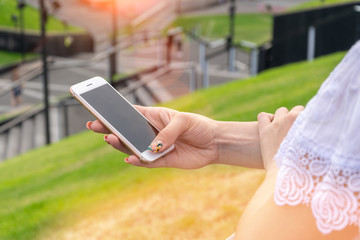 Woman texting on smart phone on during sunset