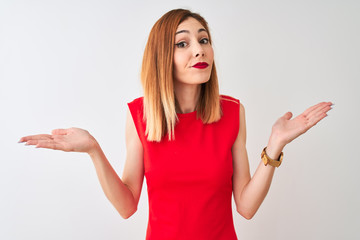 Redhead businesswoman wearing elegant red dress standing over isolated white background clueless...
