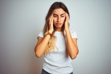 Young beautiful woman wearing casual white t-shirt over isolated background with hand on headache because stress. Suffering migraine.