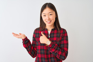 Young chinese woman wearing casual jacket standing over isolated white background Showing palm hand and doing ok gesture with thumbs up, smiling happy and cheerful