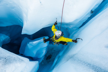 Ice climber on piller inside vertical ice cave on the Matanuska Glacier. - obrazy, fototapety, plakaty
