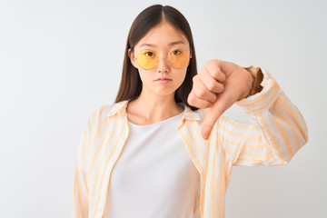 Young chinese woman wearing striped shirt and glasses over isolated white background with angry...