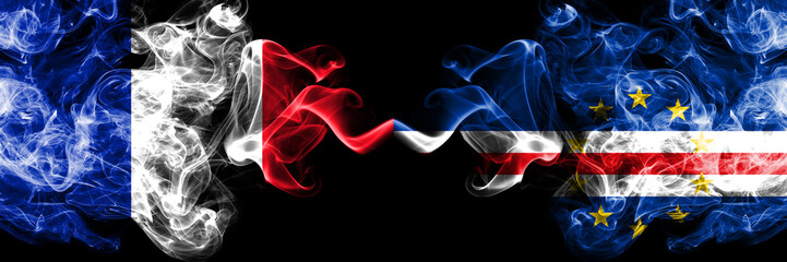 France vs Cape Verde smoky mystic flags placed side by side. Thick colored silky abstract smoke banner of French and Cape Verde
