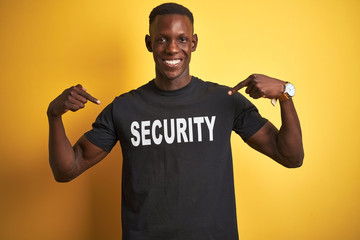 African american safeguard man wearing security uniform over isolated yellow background looking...