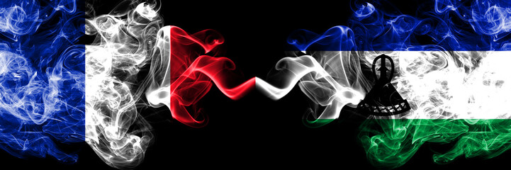 France vs Lesotho smoky mystic flags placed side by side. Thick colored silky abstract smoke banner of French and Lesotho