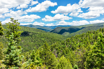 Carson National Forest with Sangre de Cristo mountains and green pine trees in summer and peak overlook from route 76 high road to Taos