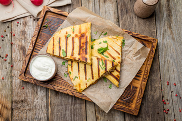 Quesadilla with beef and sauces on old wooden table