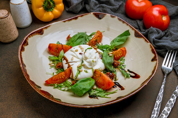 Salad with buratta cheese on dark rustic background