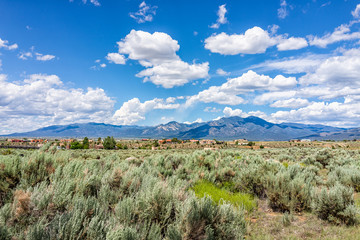 View of Taos Sangre de Cristo mountains view from Ranchos de Taos valley and green landscape in...