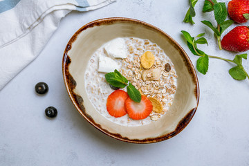 Oatmeal with berries on grey background