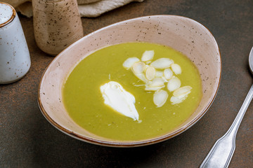 Cream of broccoli soup on dark rustic background