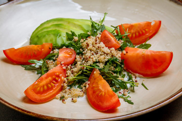 Quinoa side dish with onions and vegetables on wooden table