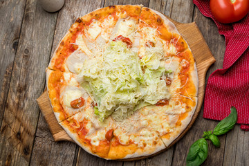 Pizza Caesar on plate on old wooden table