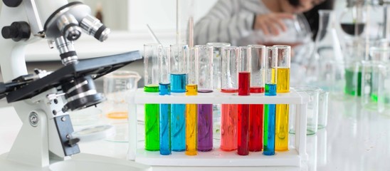 Kid learning science in chemical laboratory.