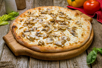 pizza with mushrooms on old wooden table
