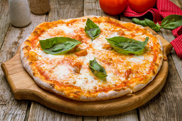 Italian pizza Margherita on old wooden table
