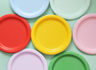 Colorful paper plates on light background.