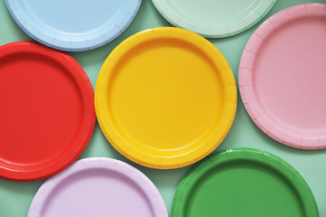 Colorful paper plates on light background.